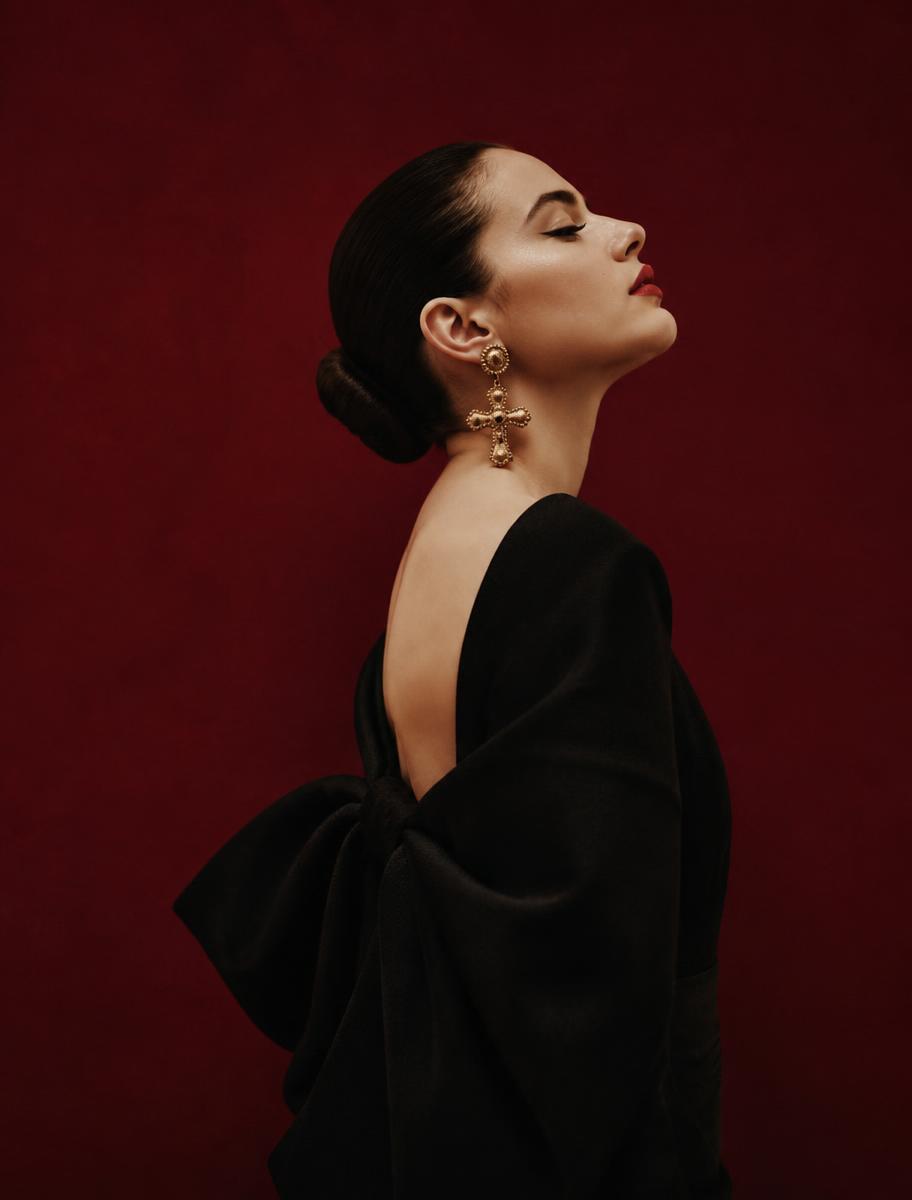 Model in profile against an oxblood backdrop